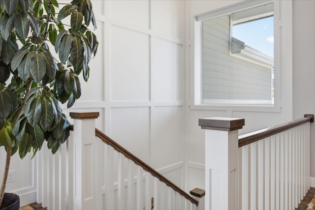21 Pier Place Tooele, UT 84074 - Photo 7 of 112 Staircase featuring white board and batten wall paneling, white balusters, and dark wood-finish newel posts and handrails