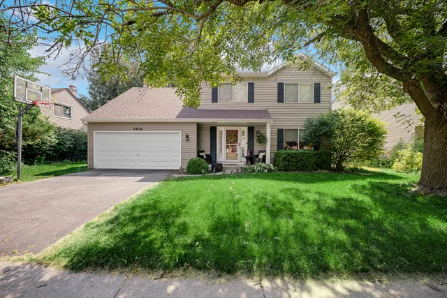 a front view of a house with a yard and trees