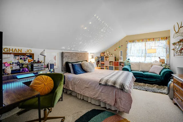 a spacious bedroom with a bed and large windows