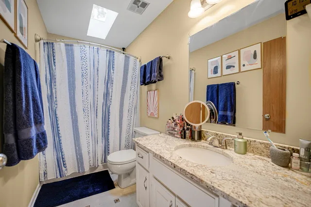 a bathroom with a granite countertop sink toilet and shower