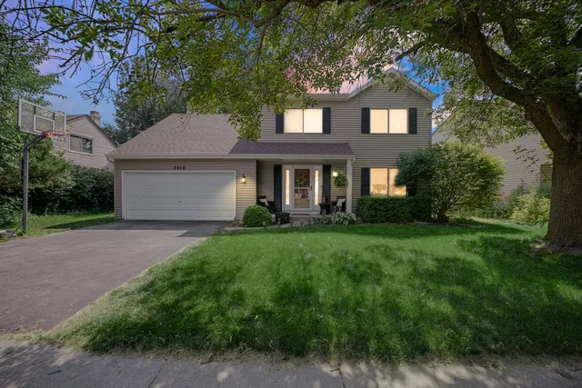 a front view of a house with yard and green space