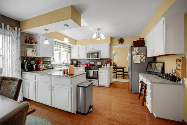 a kitchen with cabinets and chairs