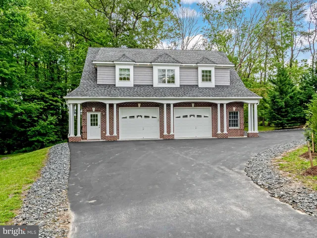 a view of a house with a yard and large tree