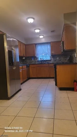 a kitchen with stainless steel appliances granite countertop a refrigerator and a stove top oven