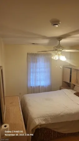 a large bed sitting in a bedroom and chandelier