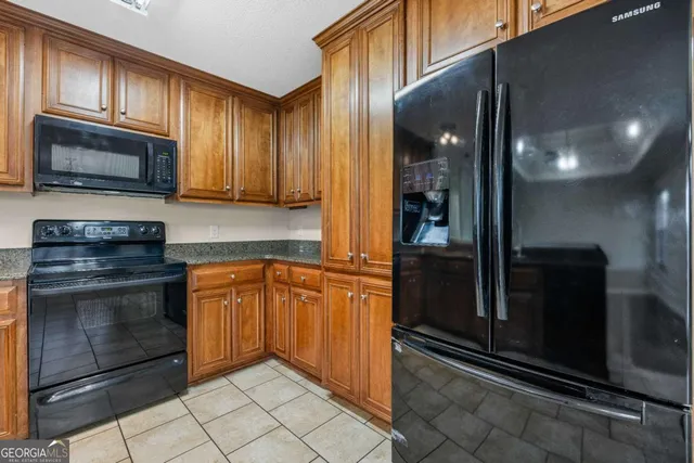 a kitchen with granite countertop stainless steel appliances white cabinets and a sink