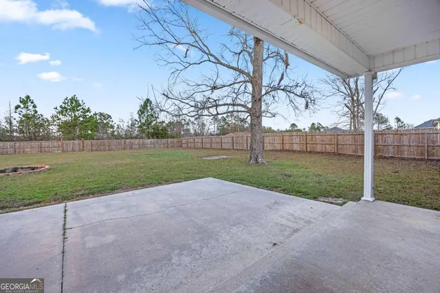 a view of a backyard with wooden fence