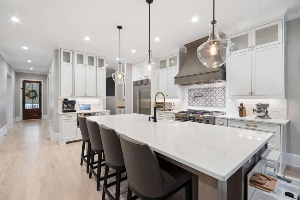2561 Thompson Road Northeast Brookhaven, GA 30319 - Photo 6 of 47 a large kitchen with granite countertop a stove a sink a center island a table and chairs