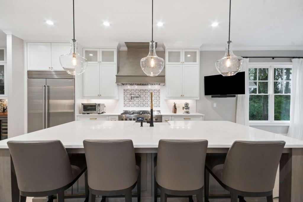 2561 Thompson Road Northeast Brookhaven, GA 30319 - Photo 7 of 47 a kitchen with kitchen island a dining table chairs and a wooden floor