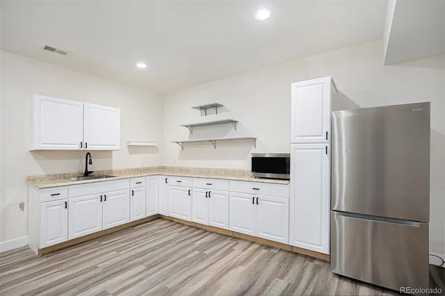 a kitchen with white cabinets and stainless steel appliances