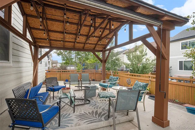 a view of a patio with a dining table and chairs with wooden floor