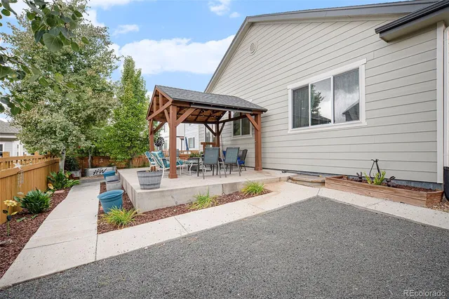 a view of a house with backyard and sitting area