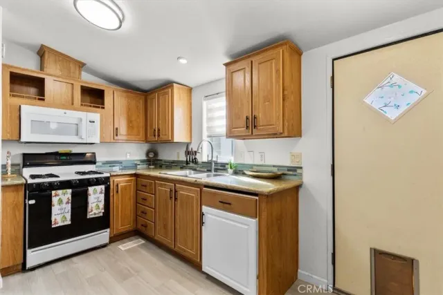 a kitchen with stainless steel appliances granite countertop a stove a sink and a microwave