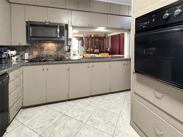 a kitchen with granite countertop a sink and cabinets
