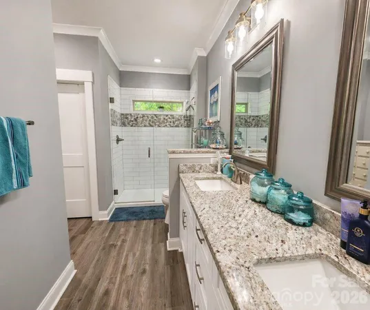 a room with kitchen island granite countertop wooden floor and a large window