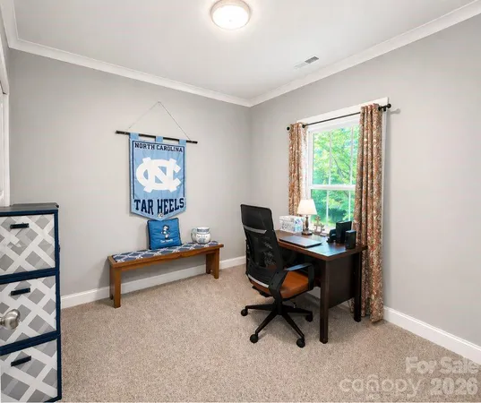 a view of a workspace with furniture and a window