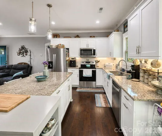 a kitchen with kitchen island granite countertop a sink appliances cabinets and a counter top space