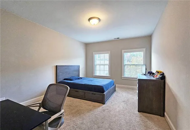 a bedroom with a bed and windows