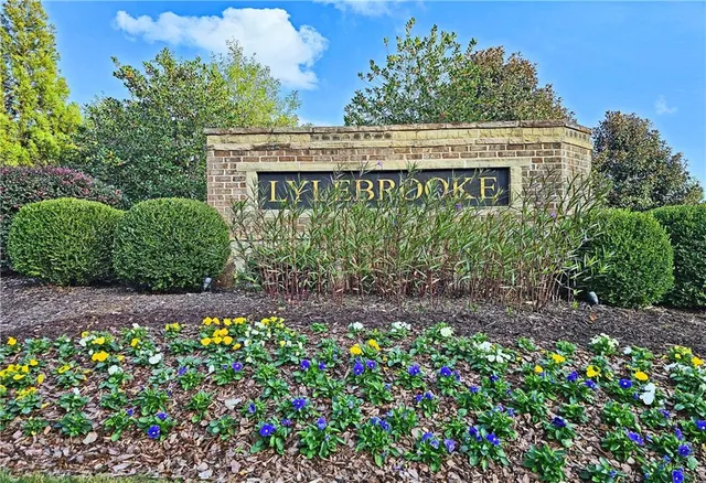 a front view of a house with a yard and fountain in middle of the house