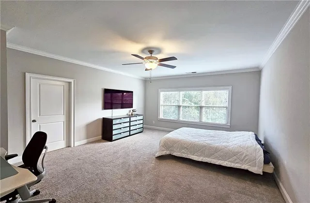 a bedroom with a bed a computer on a desk and a dresser