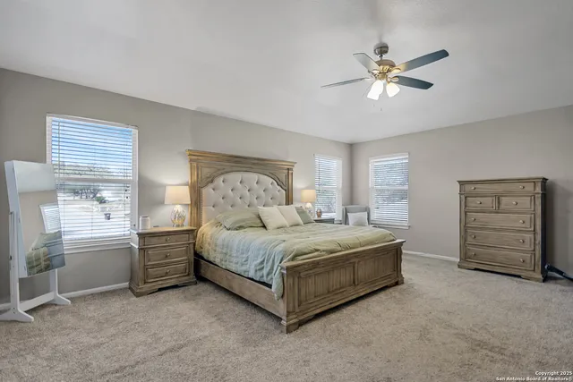 a spacious bedroom with a bed and a cabinets