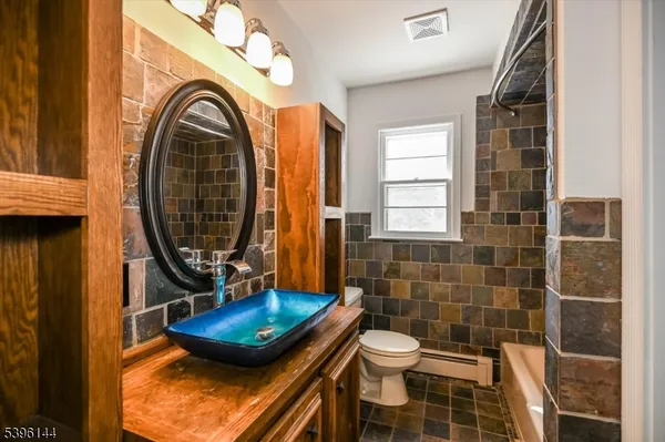 a bathroom with a toilet a sink and a mirror
