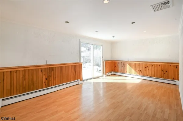 a view of an empty room with wooden floor
