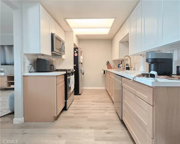 a kitchen with sink cabinets and a wooden floor