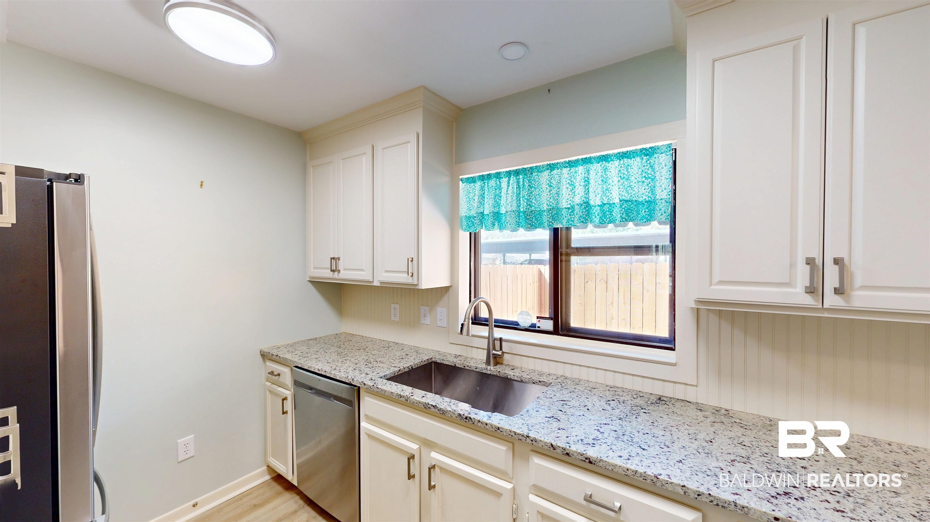 2901 Grant Street, Unit 902 Mobile, AL 36606 - Photo 6 of 35 Kitchen with stainless steel appliances, light stone countertops, white cabinetry, and light wood-style flooring