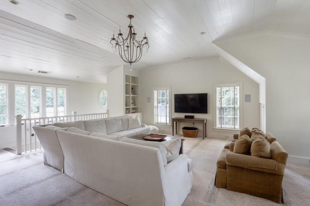 a living room with furniture a flat screen tv and a large window