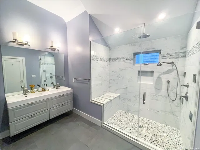 a bathroom with a double vanity sink mirror and shower