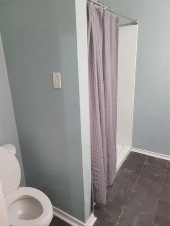a white toilet sitting next to a shower
