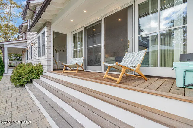 a view of a patio with couches table and chairs under an umbrella