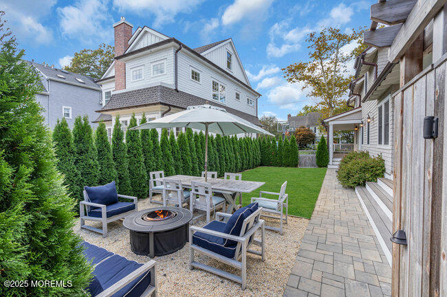 1204 5th Avenue Spring Lake, NJ 07762 - Photo 33 of 36 a view of a patio with table and chairs potted plants and a fire pit