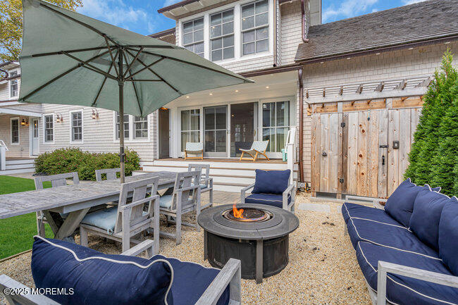 1204 5th Avenue Spring Lake, NJ 07762 - Photo 36 of 36 a view of a patio with couches table and chairs under an umbrella