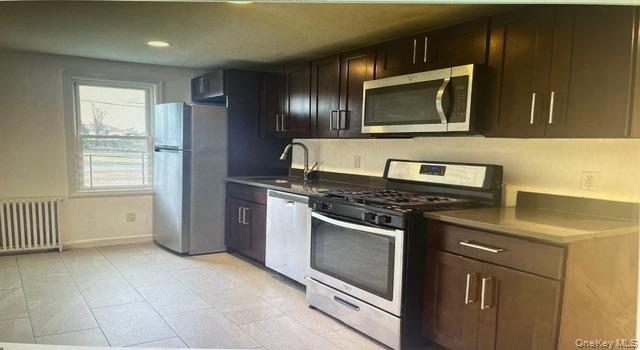 45 James Street Inwood, NY 11096 - Photo 5 of 11 a kitchen with granite countertop a stove and a microwave