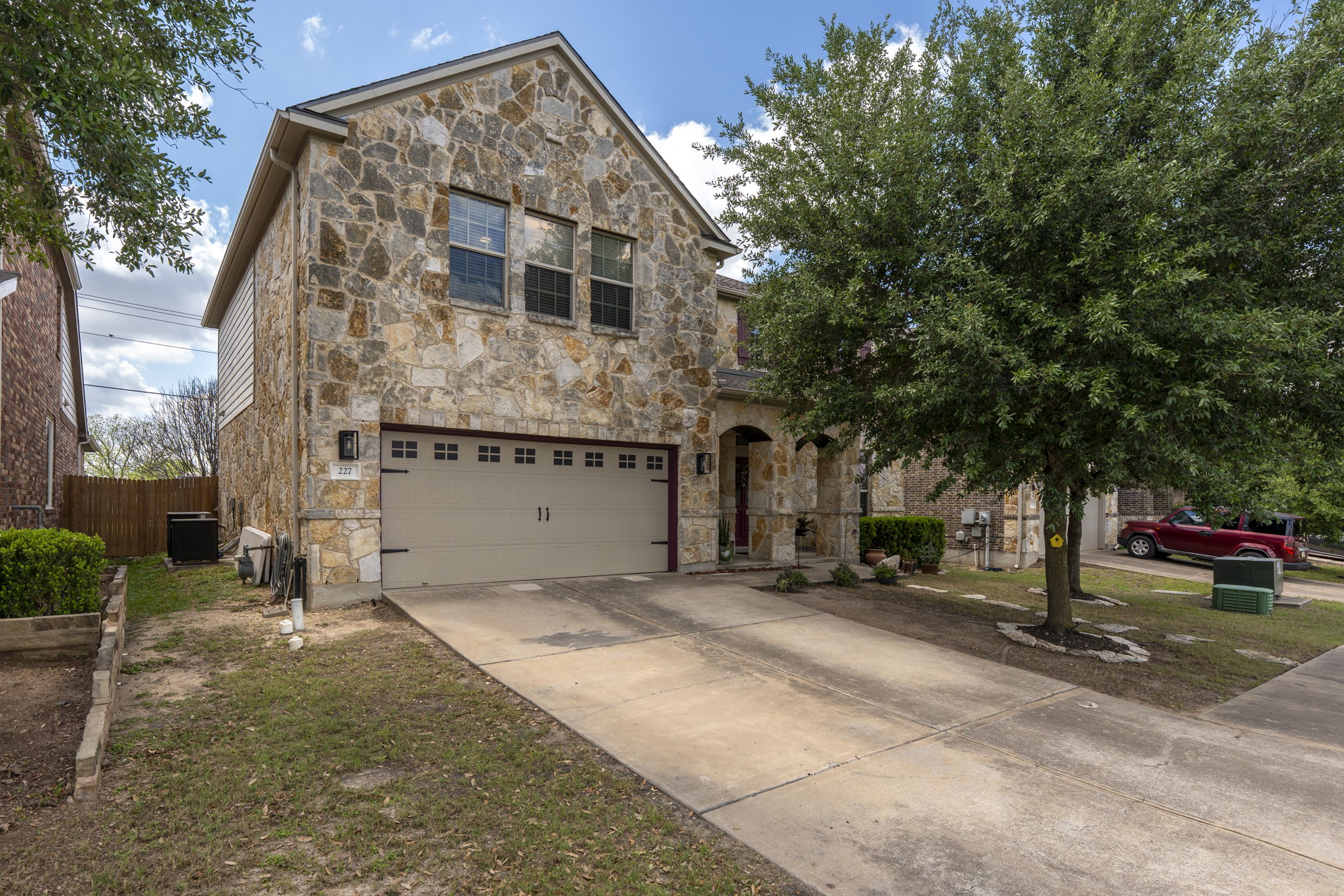 227 Sandstone Trail Buda, TX 78610 - Photo 32 of 33 Stone veneer exterior with an attached two-car garage and concrete driveway