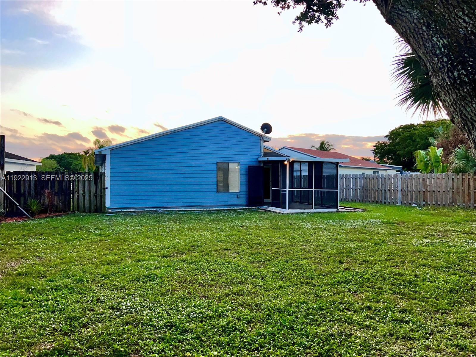 1701 Southwest 83rd Terrace Miramar, FL 33025 - Photo 17 of 18 a view of a backyard with potted plants and wooden fence