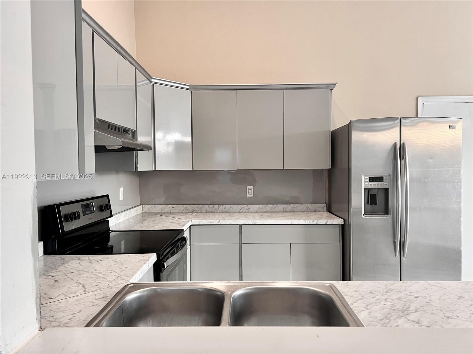 1701 Southwest 83rd Terrace Miramar, FL 33025 - Photo 4 of 18 a kitchen with stainless steel appliances granite countertop a refrigerator a sink a stove and white cabinets