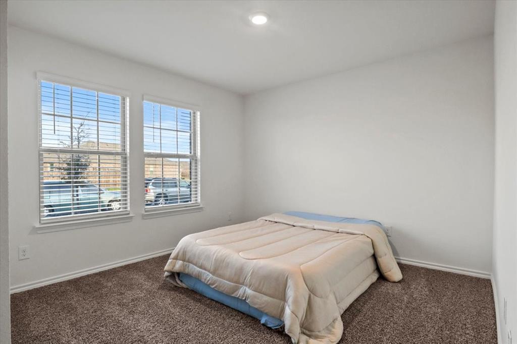804 Roland Drive Fate, TX 75189 - Photo 19 of 27 a bedroom with a bed and a window