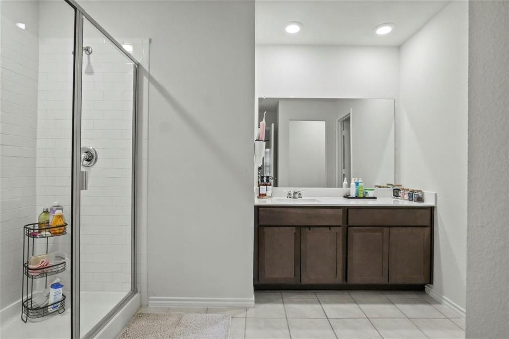 804 Roland Drive Fate, TX 75189 - Photo 24 of 27 Bathroom featuring an enclosed shower, vanity, and tile patterned floors