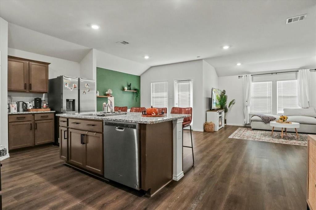 804 Roland Drive Fate, TX 75189 - Photo 4 of 27 Kitchen featuring vaulted ceiling, appliances with stainless steel finishes, a kitchen island with sink, and dark hardwood / wood-style flooring