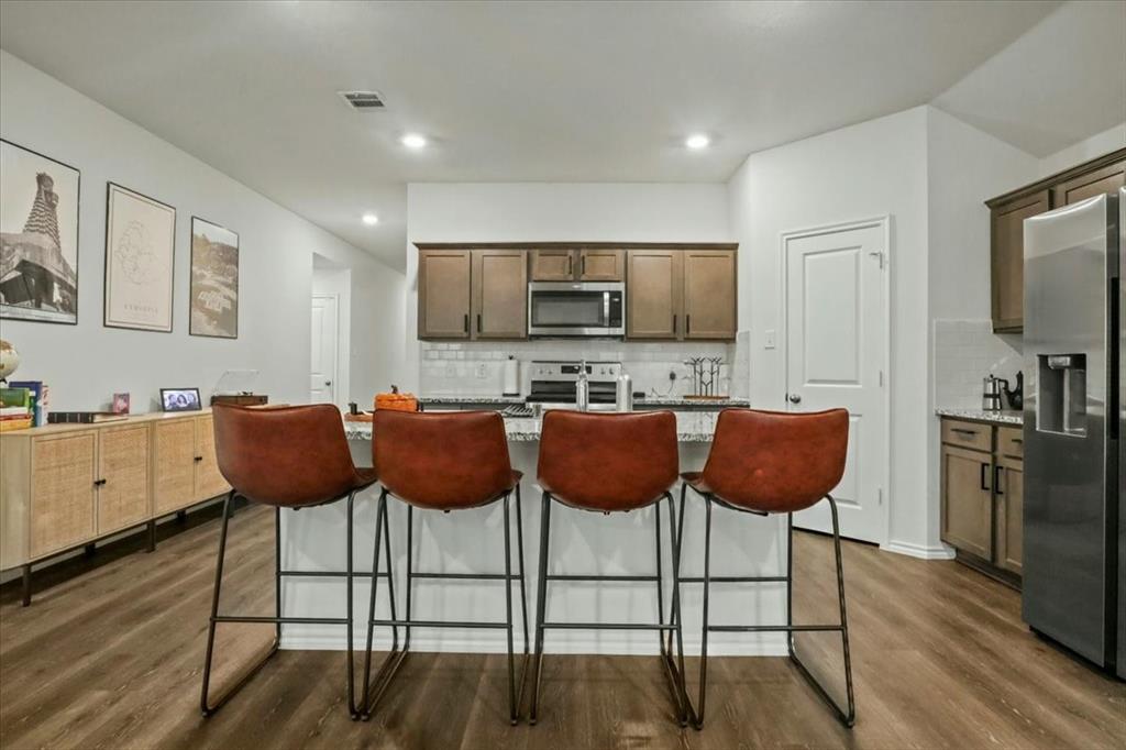 804 Roland Drive Fate, TX 75189 - Photo 10 of 27 a kitchen with stainless steel appliances kitchen island granite countertop a sink and cabinets