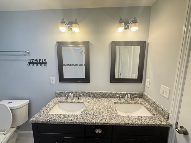a bathroom with a granite countertop sink and a mirror
