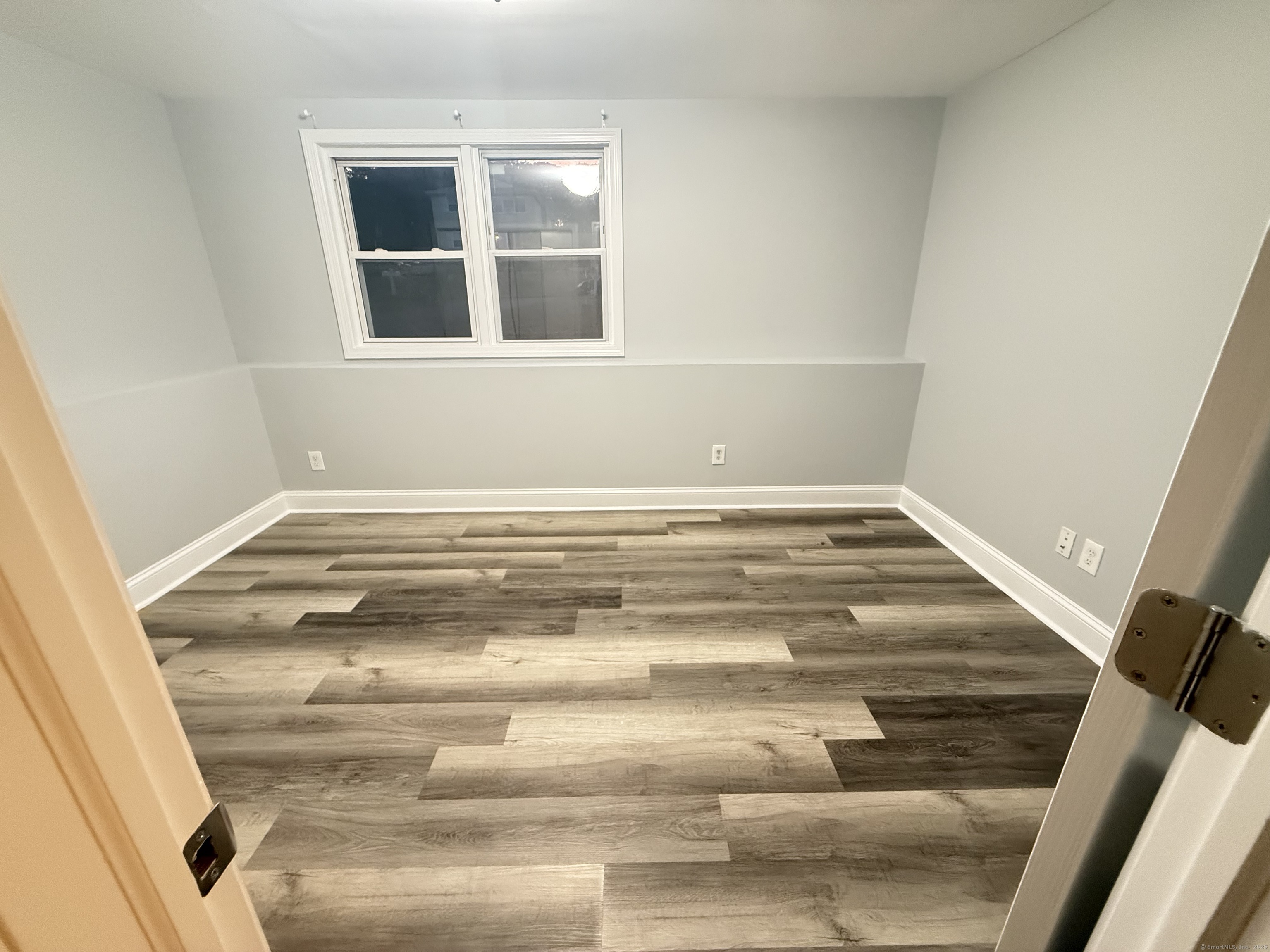 65 Muir Terrace, Unit 1 Southington, CT 06489 - Photo 23 of 24 a view of an empty room with wooden floor and a window