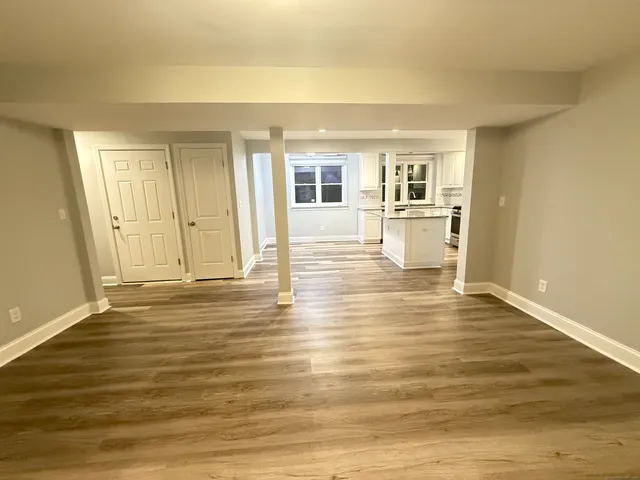 a view of empty room with wooden floor and fireplace