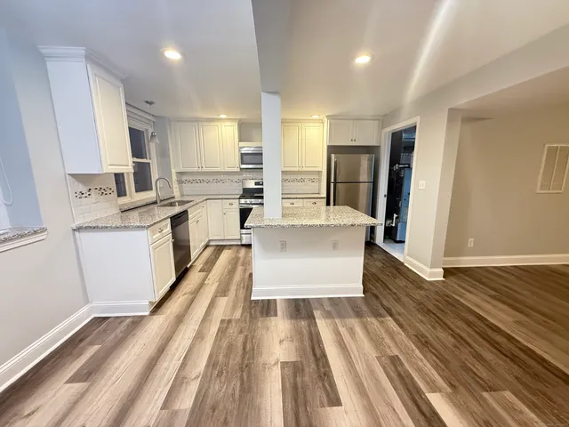 a large white kitchen with a large window
