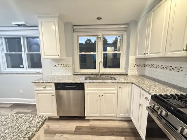 a kitchen with stainless steel appliances granite countertop a stove and cabinets