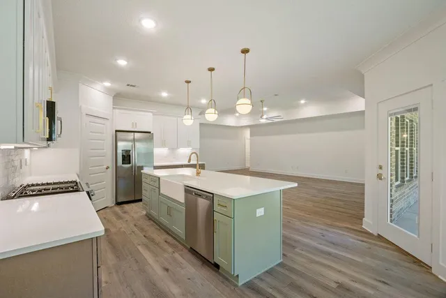a kitchen with a sink stainless steel appliances a counter space and wooden floor