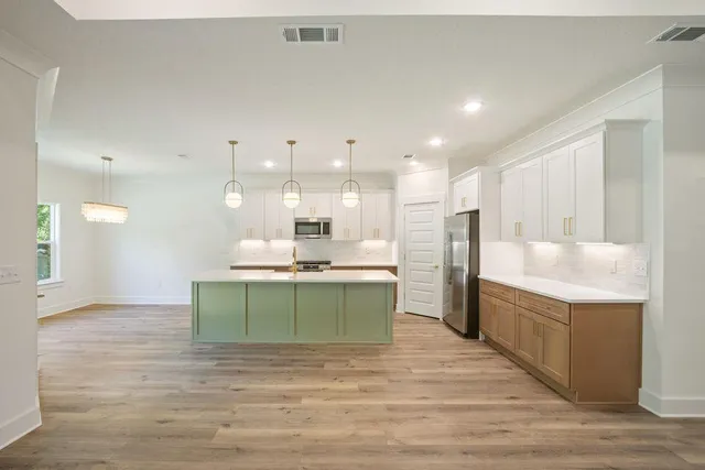 a kitchen with stainless steel appliances kitchen island a cabinets and wooden floor